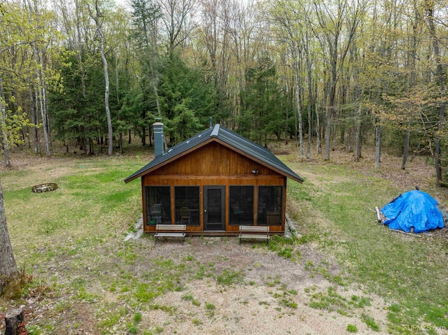E6659 Crossover Rd, Munising, MI 49862 - back of property with a sunroom, a chimney, a view of trees, and a yard