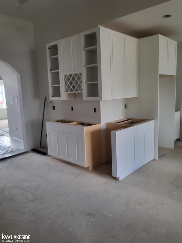 19279 Springbrook Dr Unit 175, Macomb Twp, MI 48044 - kitchen with arched walkways, open shelves, and white cabinetry