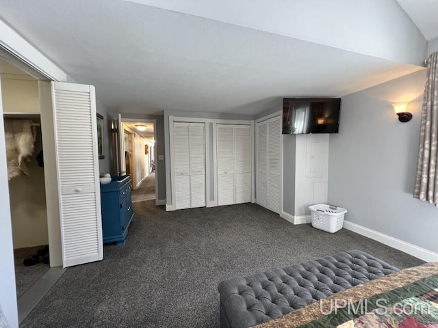 E3117 H44 Hwy, Trenary, MI 49891 - unfurnished bedroom with multiple closets, dark carpet, and baseboards