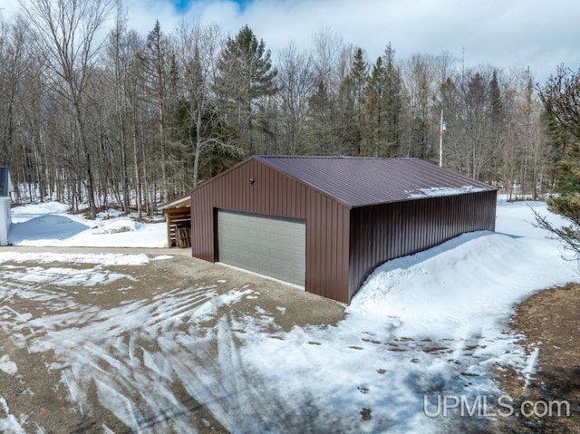 E3117 H44 Hwy, Trenary, MI 49891 - snow covered garage featuring a garage and a wooded view
