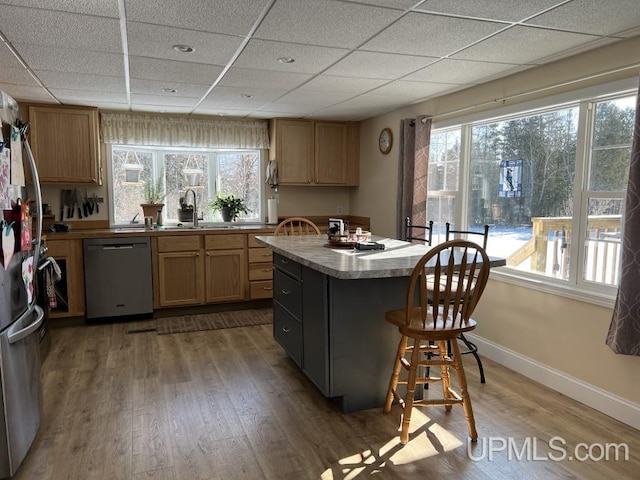 E3117 H44 Hwy, Trenary, MI 49891 - kitchen featuring appliances with stainless steel finishes, a sink, a paneled ceiling, wood finished floors, and a kitchen bar