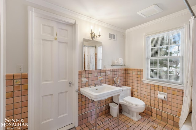 full bathroom with tile walls, toilet, tile patterned flooring, visible vents, and ornamental molding