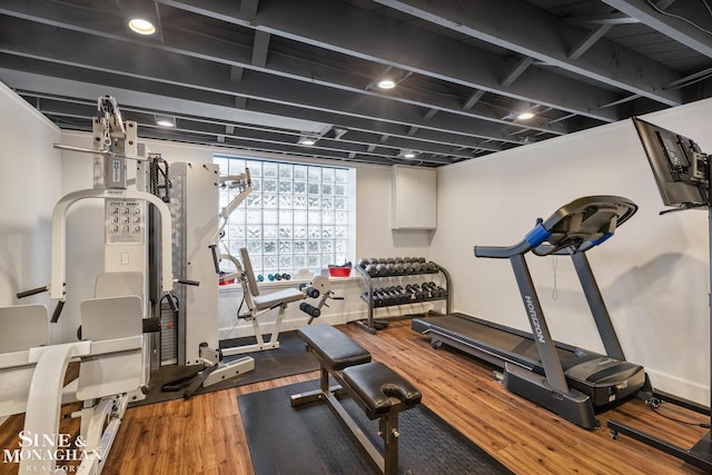 exercise room with baseboards and wood finished floors