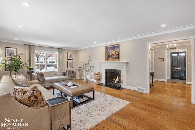 living room featuring light wood-type flooring, an inviting chandelier, recessed lighting, visible vents, and a brick fireplace
