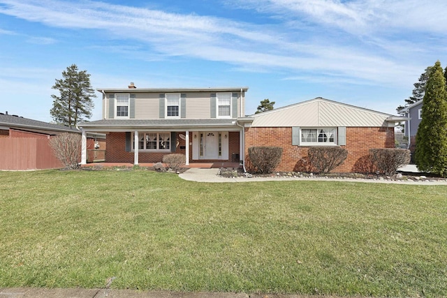 traditional-style home with brick siding, fence, a porch, and a front yard