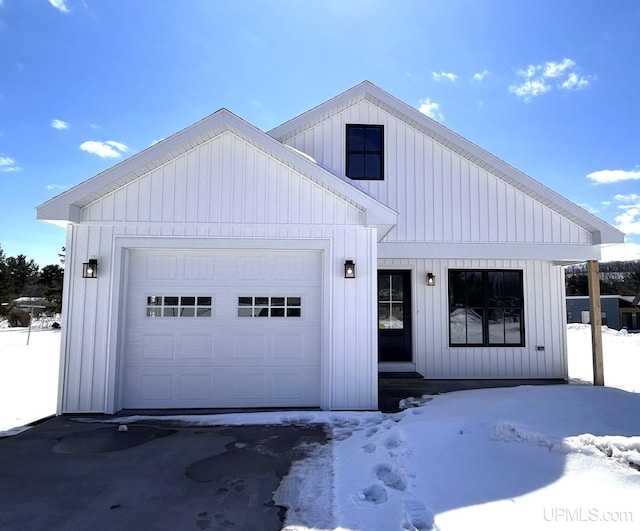 modern inspired farmhouse featuring board and batten siding and a garage