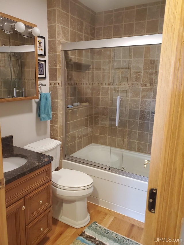 49436 S Superior Rd, Houghton, MI 49931 - full bathroom with toilet, shower / bath combination with glass door, vanity, and wood finished floors