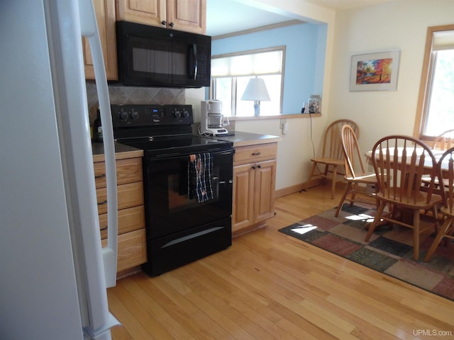 49436 S Superior Rd, Houghton, MI 49931 - kitchen featuring a wealth of natural light, decorative backsplash, black appliances, and light wood-style floors