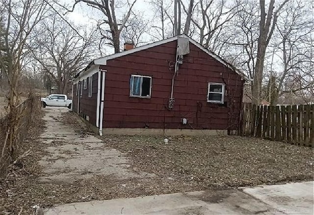 view of property exterior featuring fence and a chimney
