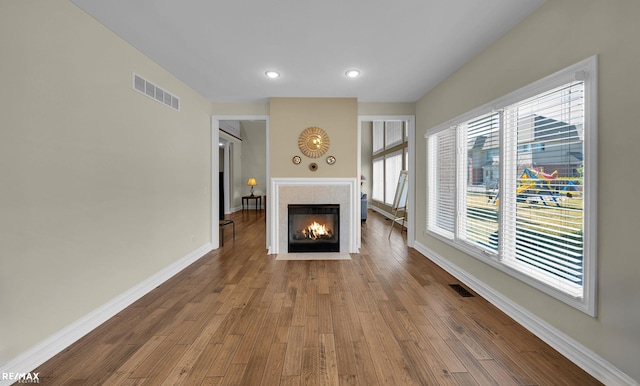 55763 Omni Dr, Shelby, MI 48315 - unfurnished living room with wood finished floors, baseboards, visible vents, and a tile fireplace