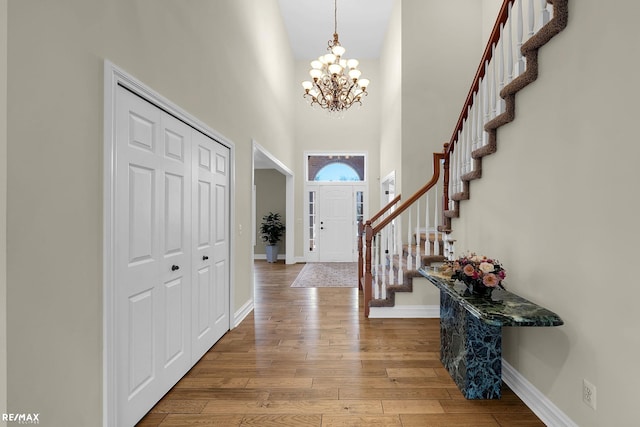55763 Omni Dr, Shelby, MI 48315 - entrance foyer featuring a towering ceiling, baseboards, a chandelier, stairway, and wood finished floors
