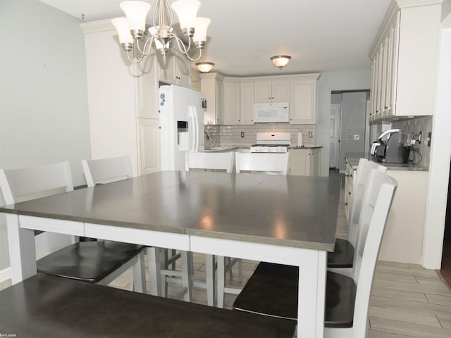 dining area with a notable chandelier and light wood-type flooring