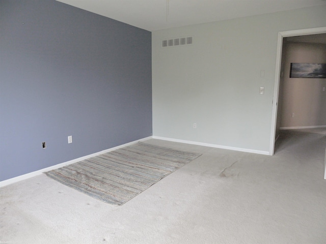spare room with visible vents, baseboards, and carpet floors