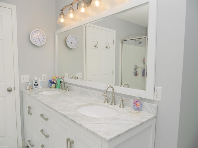 full bath featuring double vanity, a sink, and a shower with door