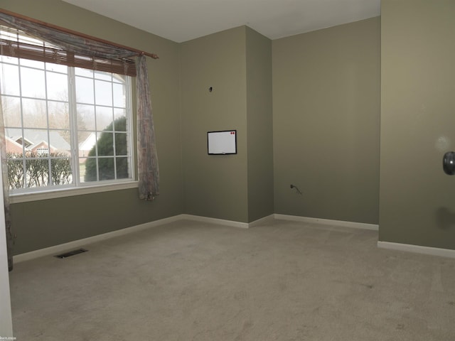 spare room featuring carpet flooring, visible vents, and baseboards