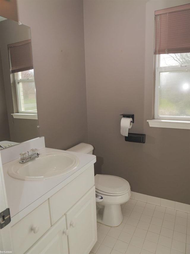 half bath featuring tile patterned flooring, vanity, and toilet