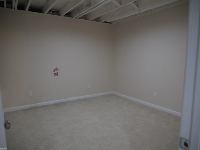 unfurnished room with baseboards and light carpet