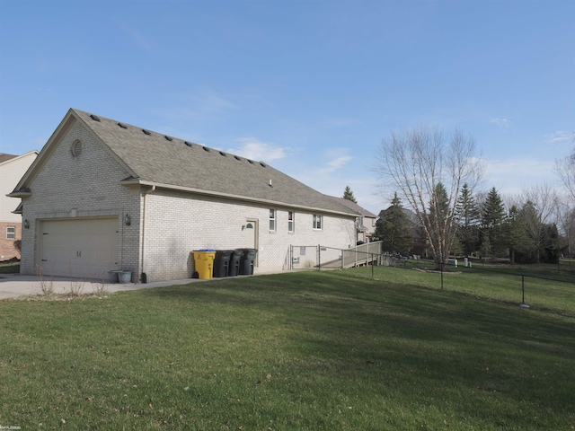 view of property exterior featuring concrete driveway, a yard, brick siding, and fence