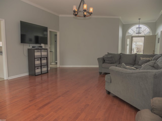 living room with crown molding, baseboards, a chandelier, and wood finished floors