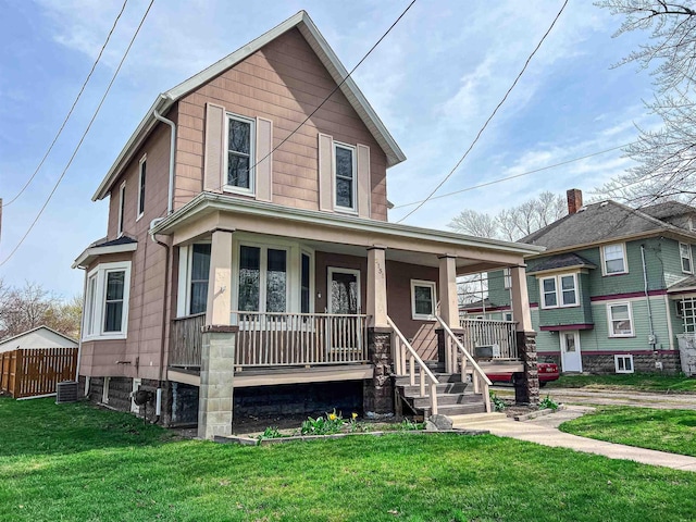 view of front of home featuring central AC, a front yard, covered porch, and fence
