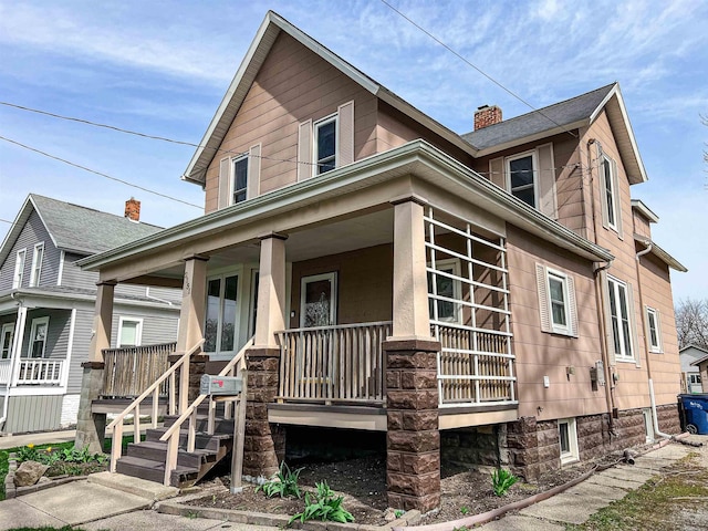 view of front facade with a chimney and a porch