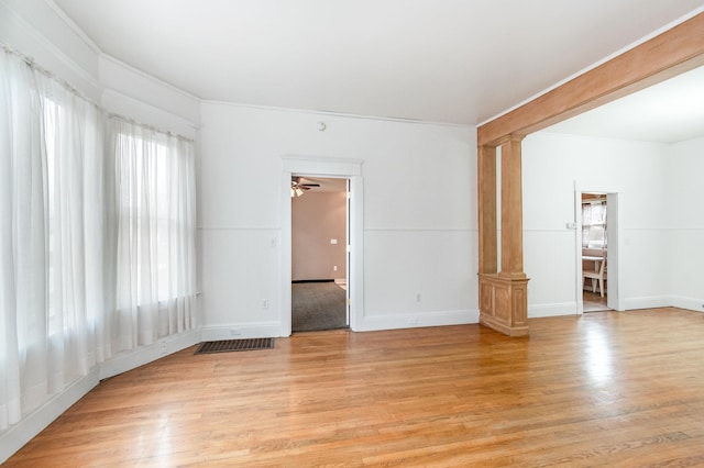 unfurnished living room featuring light wood-style flooring, visible vents, baseboards, and decorative columns