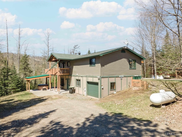 126 Big Bear Rd, Iron River, MI 49935 - view of side of property featuring a hot tub, driveway, and a patio