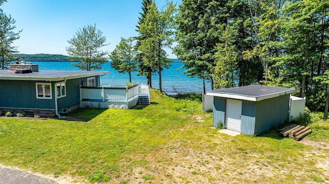view of yard with a deck with water view and an outdoor structure