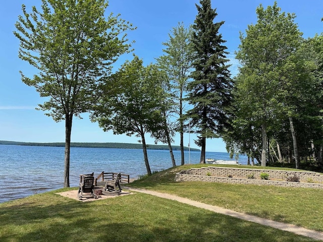 view of home's community with a water view and a yard
