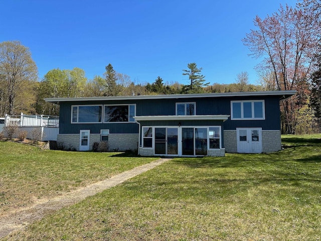 rear view of house with a yard and a sunroom