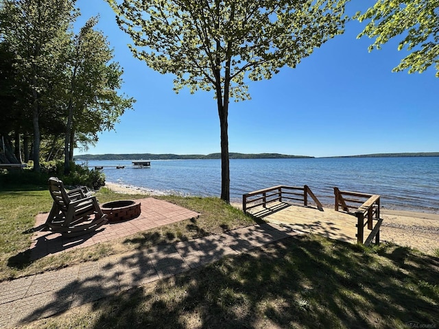 exterior space with a water view and an outdoor fire pit