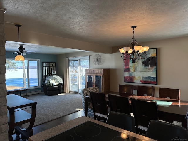 dining space featuring a textured ceiling, wood finished floors, and ceiling fan with notable chandelier