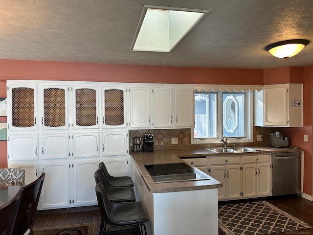 kitchen with white cabinetry, stainless steel dishwasher, a sink, and black electric cooktop