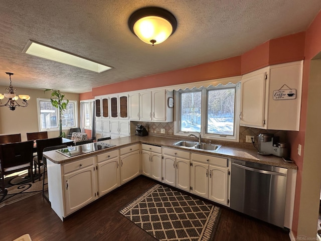 kitchen with black electric stovetop, stainless steel dishwasher, a sink, and white cabinetry
