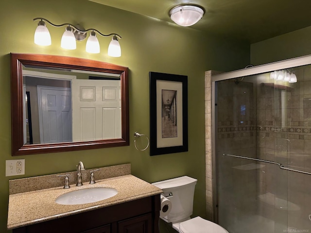 bathroom with toilet, a stall shower, and vanity