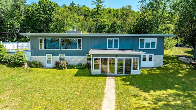 back of house with a yard and a sunroom