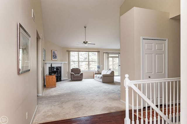living room with high vaulted ceiling, a high end fireplace, a ceiling fan, and baseboards