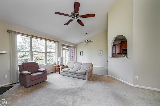 living room featuring high vaulted ceiling, carpet, baseboards, and a ceiling fan