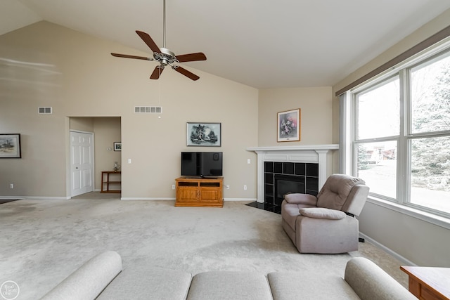 living room with visible vents, ceiling fan, light colored carpet, and a fireplace