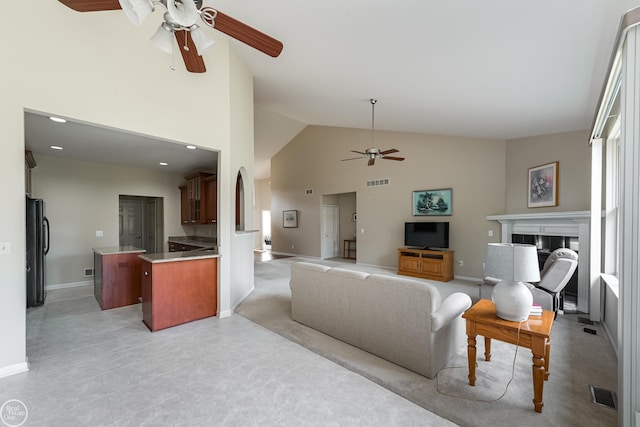 living room featuring visible vents, high vaulted ceiling, a ceiling fan, and a fireplace