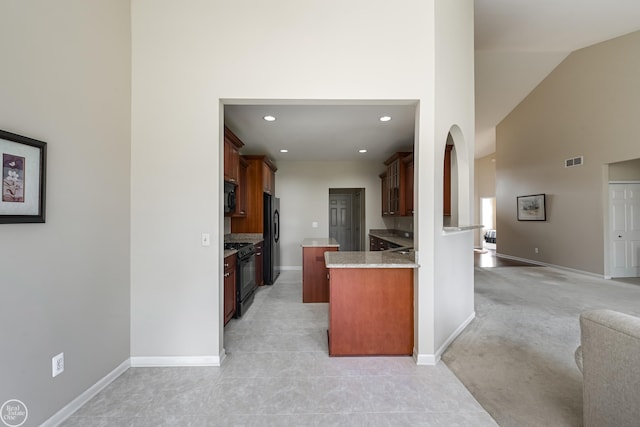 kitchen featuring visible vents, baseboards, open floor plan, black appliances, and high vaulted ceiling