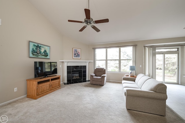 living room featuring a tile fireplace, light colored carpet, baseboards, and ceiling fan