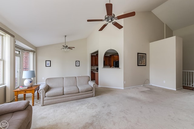 living room featuring baseboards, a ceiling fan, high vaulted ceiling, and light carpet