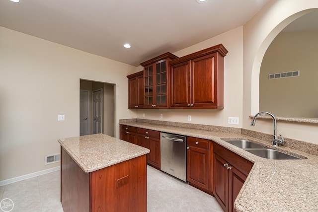 kitchen featuring stainless steel dishwasher, visible vents, a center island, and a sink