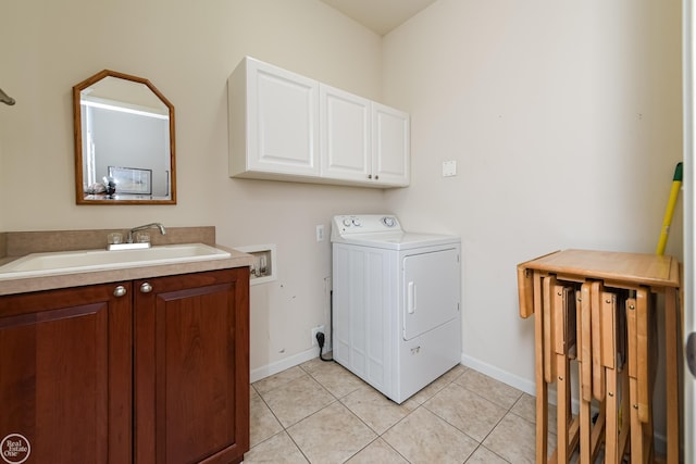 washroom featuring light tile patterned floors, washer / clothes dryer, a sink, baseboards, and cabinet space