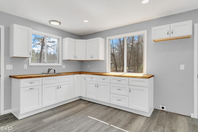 2407 Karen St, Prescott, MI 48756 - kitchen featuring butcher block counters, a sink, white cabinets, and light wood-style floors