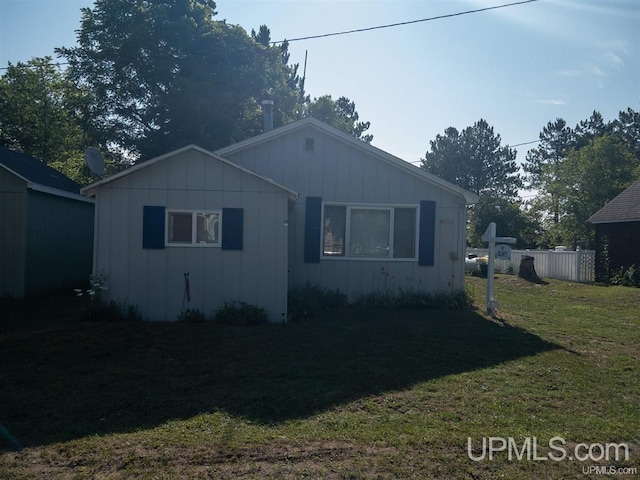 N5352 Pine St, Shingleton, MI 49884 - view of front of home with board and batten siding, fence, and a front lawn