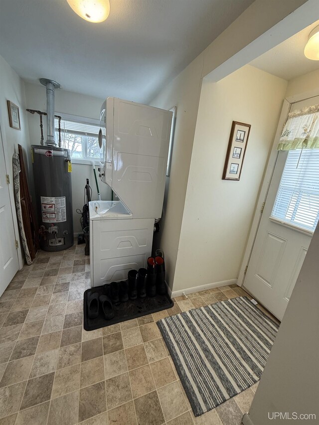 N5352 Pine St, Shingleton, MI 49884 - clothes washing area featuring stacked washing maching and dryer, laundry area, baseboards, and gas water heater