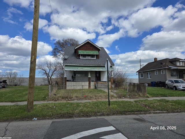 bungalow featuring roof with shingles, a fenced front yard, and a front yard