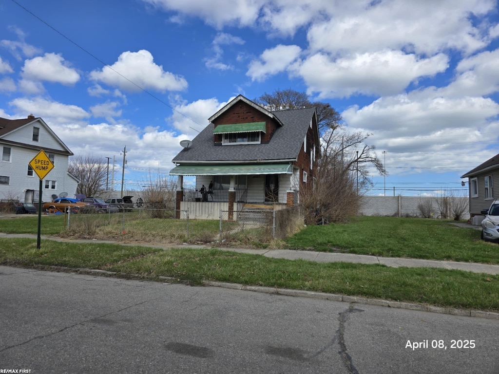 bungalow featuring a fenced front yard and a front lawn